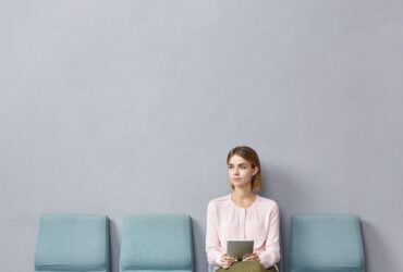 young woman sitting waiting room Zalety indywidualnych pakietów medycznych – elastyczność i personalizacja usług